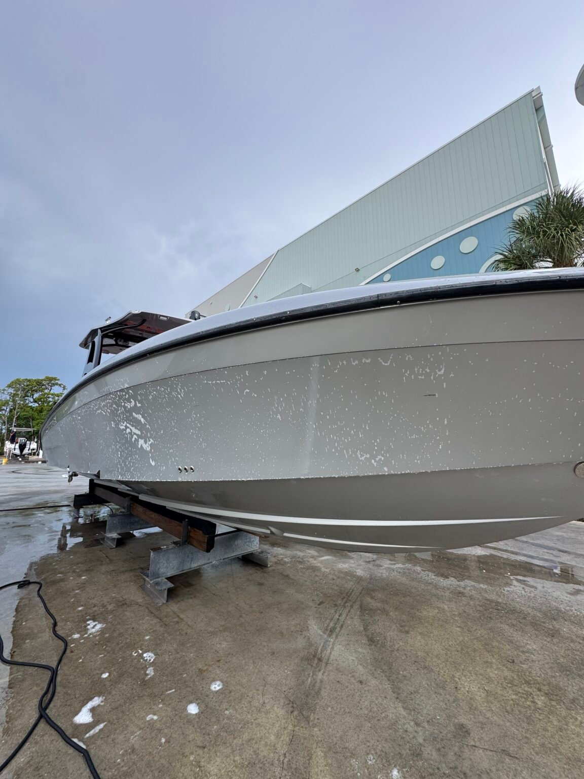 Gray center console lowered onto the cleaning rack at Haulover Marine Center