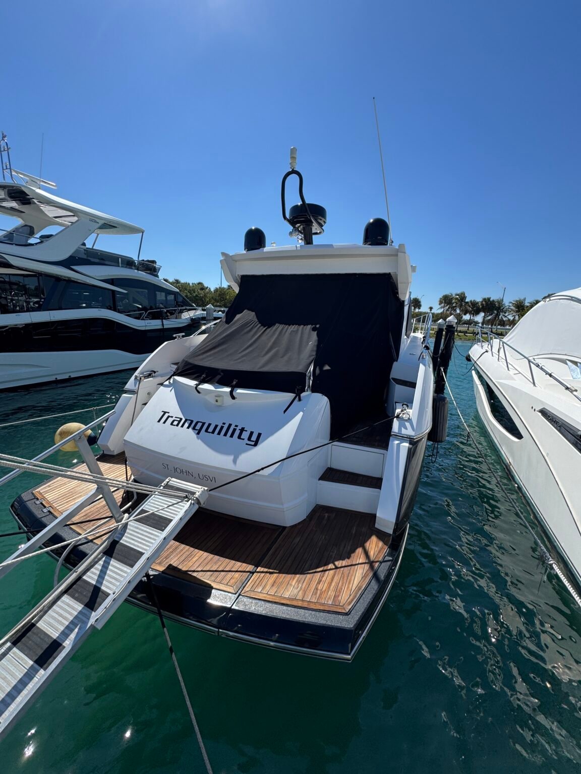 Sport yacht with teak swim platform in a wet slip at Rickenbacker Marina, after a washdown by 305 Detailing Miami