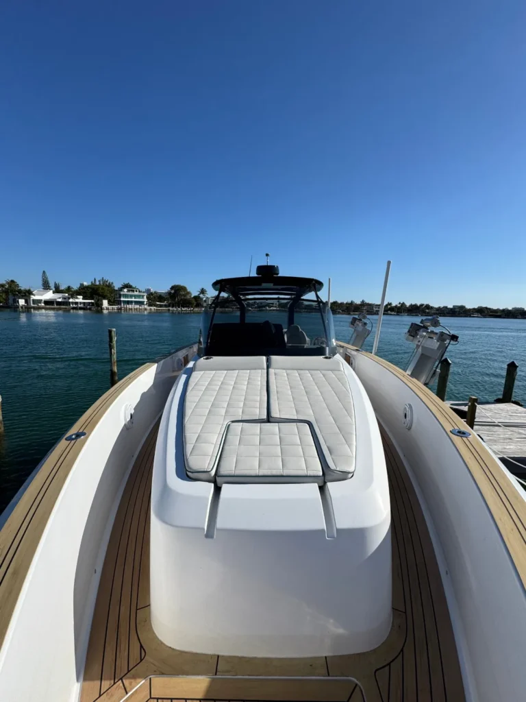 Clean dayboat bow sun pad and teak-style deck on a Miami waterway