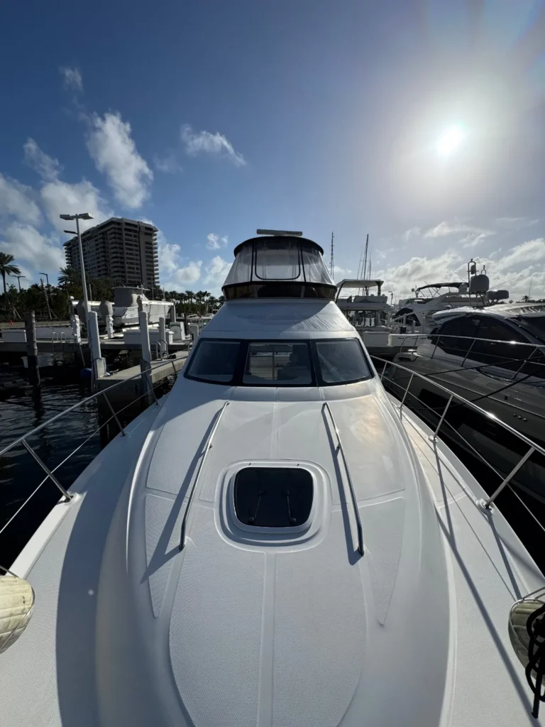 Clean white foredeck and non-skid of a flybridge yacht at a Miami marina