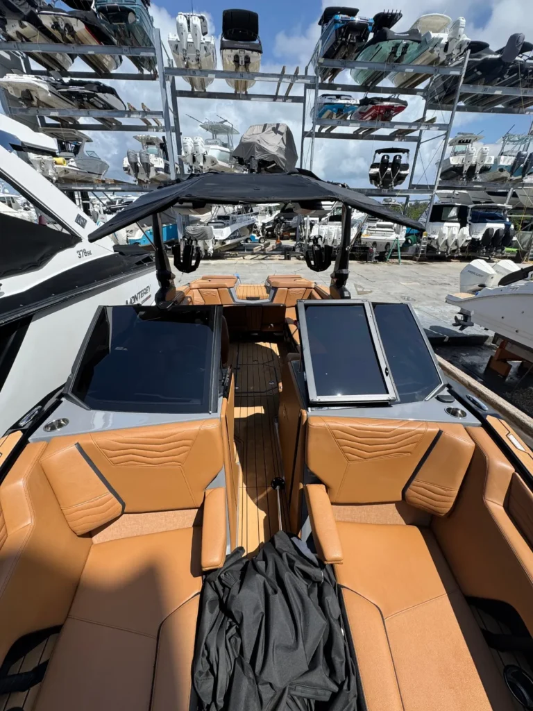 Wake boat helm and leather seats with dry stack boat racks in the background