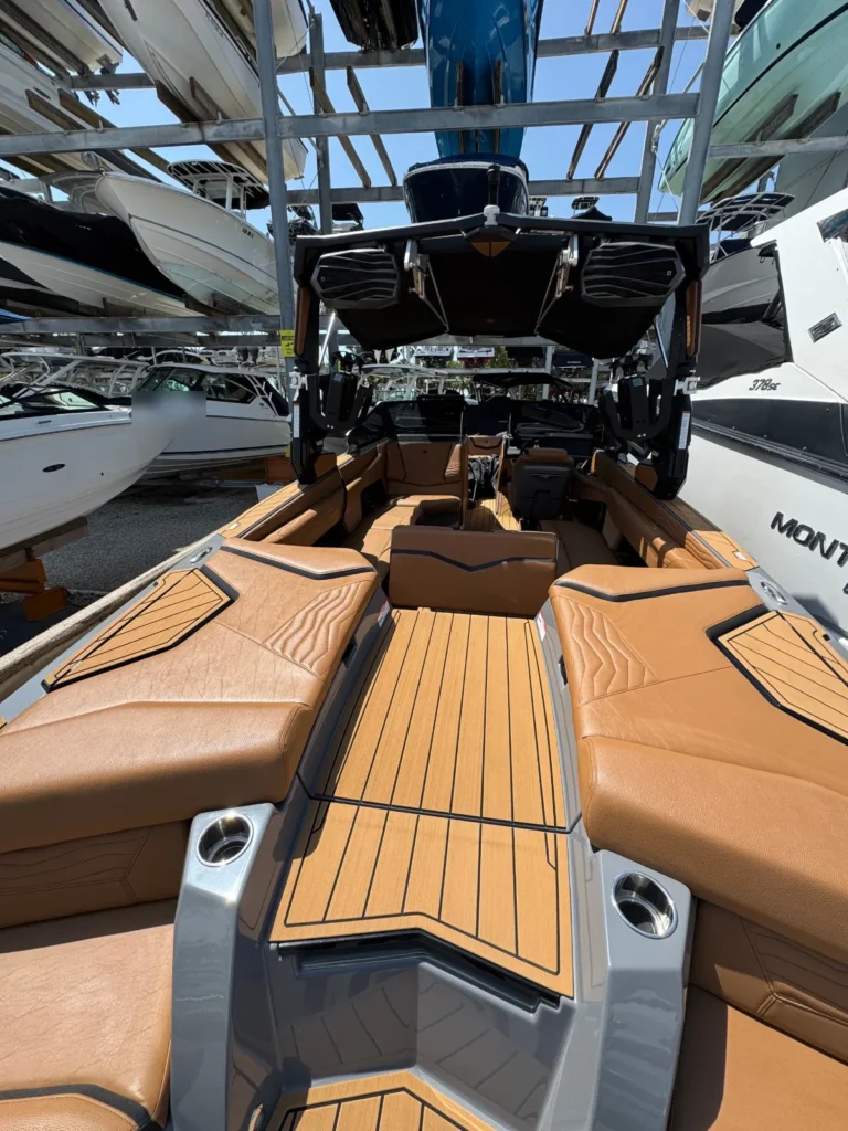 Wake boat with tan leather seats and synthetic teak floor in a Miami dry stack yard