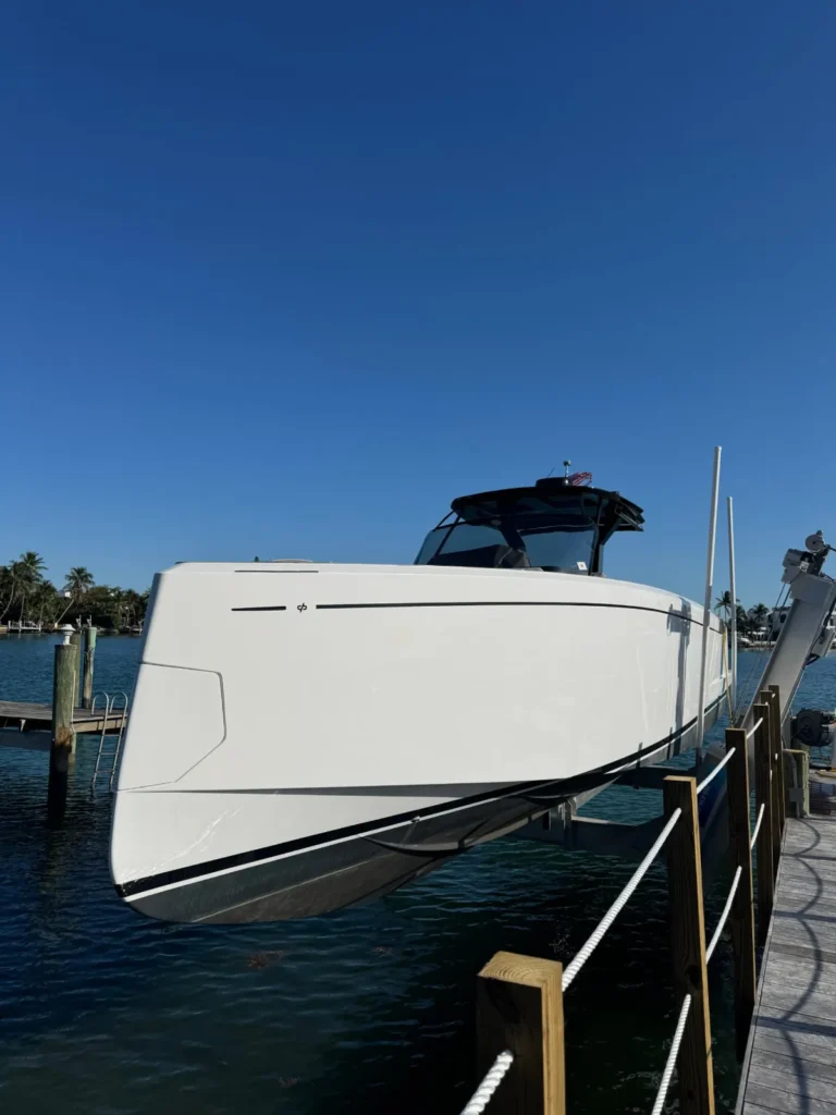 Glossy white gelcoat hull of a modern dayboat on a boat lift in Miami